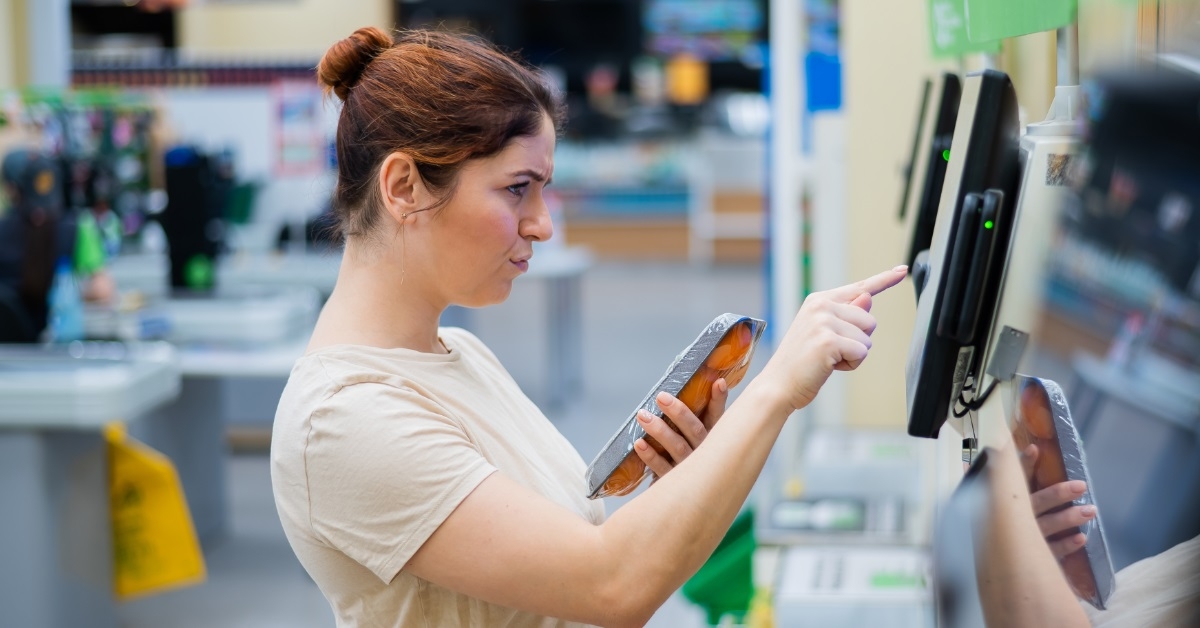 frustrated woman using self-checkout counter