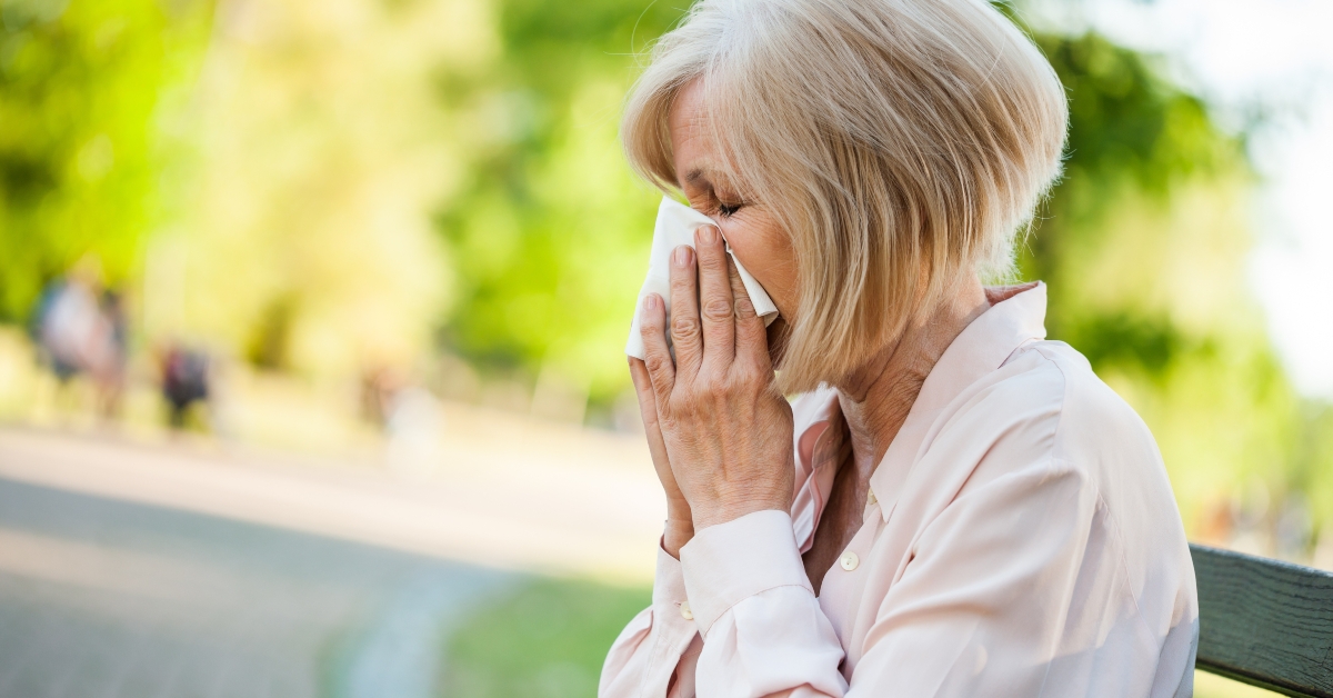 woman sitting blowing nose