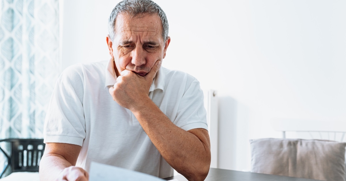 senior man reviewing bills at home
