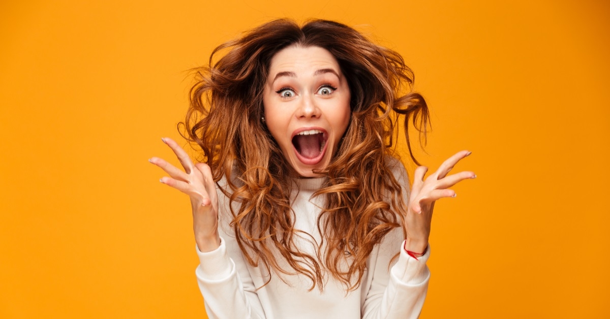 attractive woman screaming over orange background