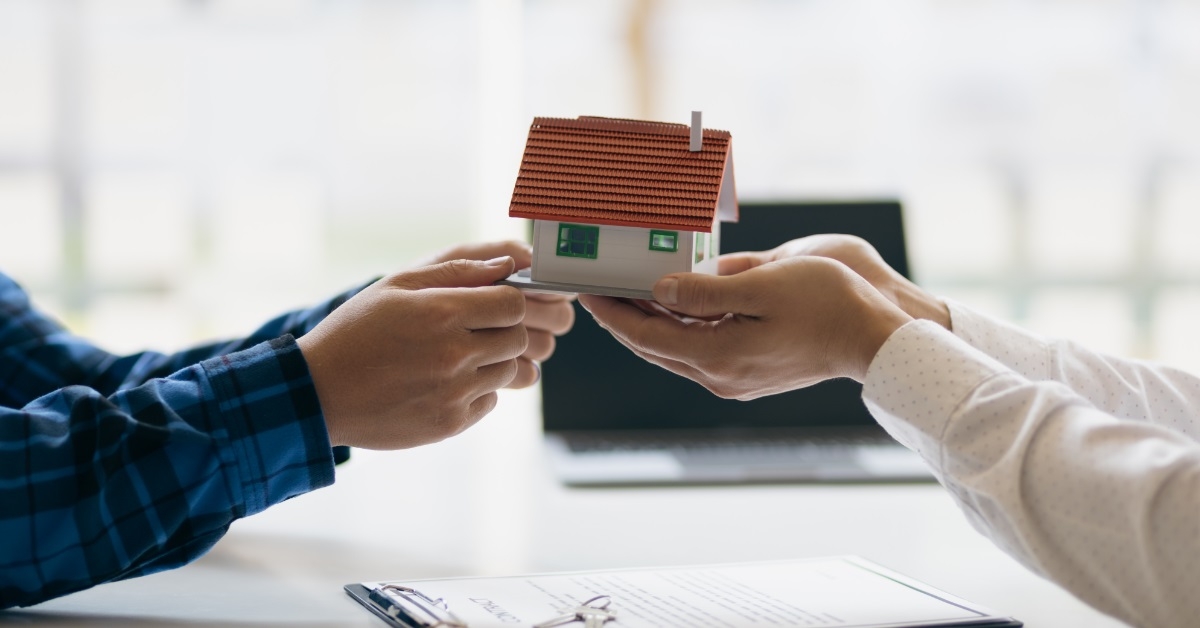 hands holding house sculpture inheritance concept