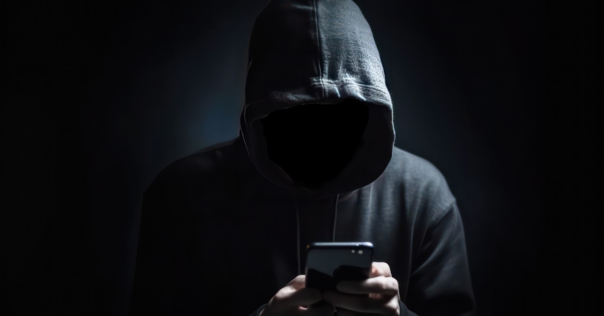 mysterious man in hoodie using smartphone