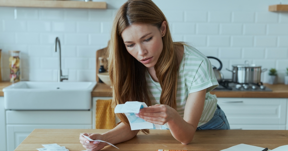 woman calculating finances at kitchen counter