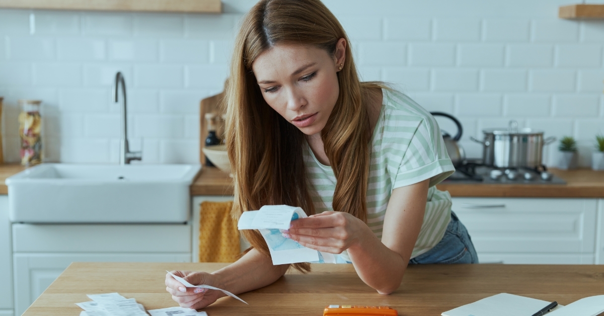 woman calculating finances in domestic kitchen