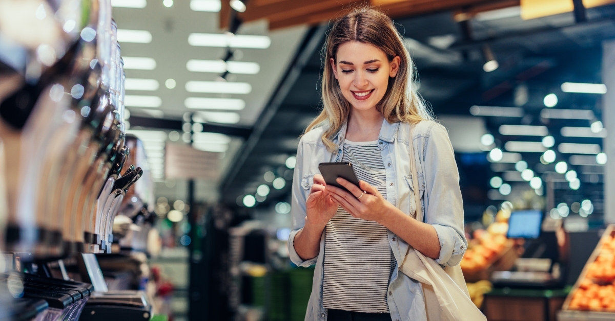 woman using smartphone at grocery store