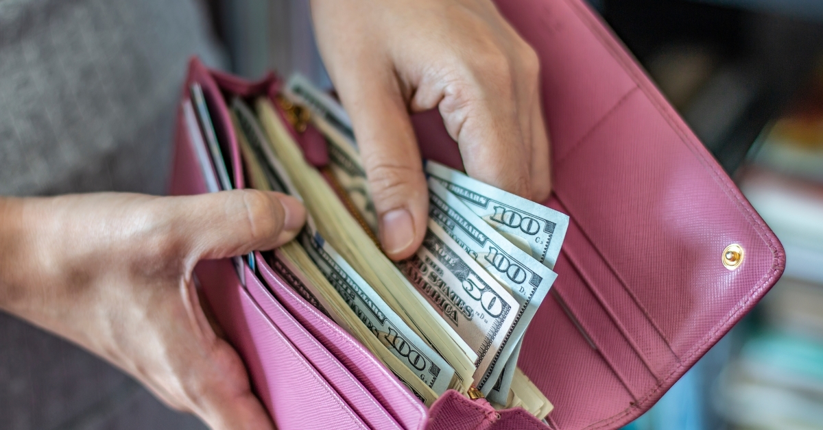 Woman taking out dollar from wallet