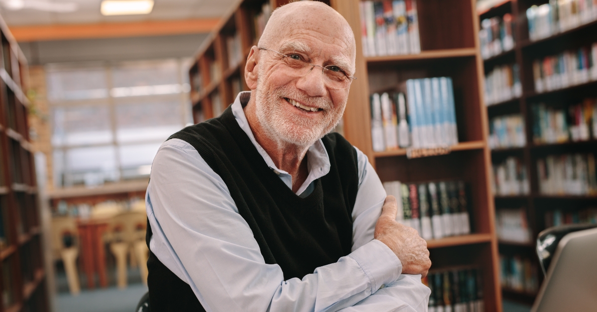 senior man sitting in a library
