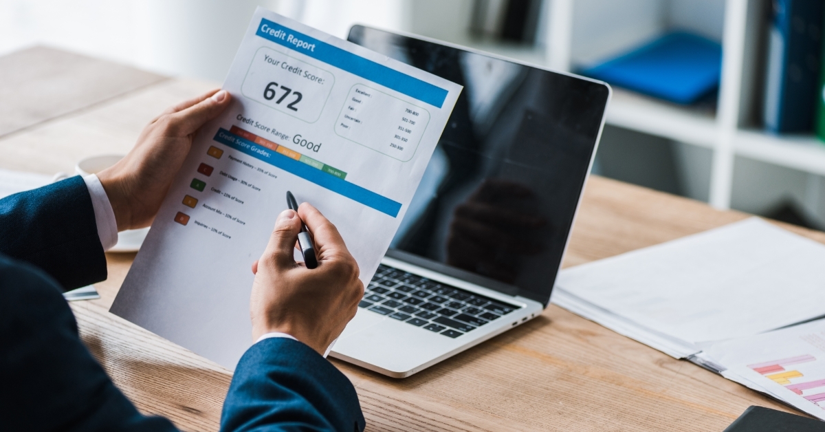 man reviewing credit report using pen