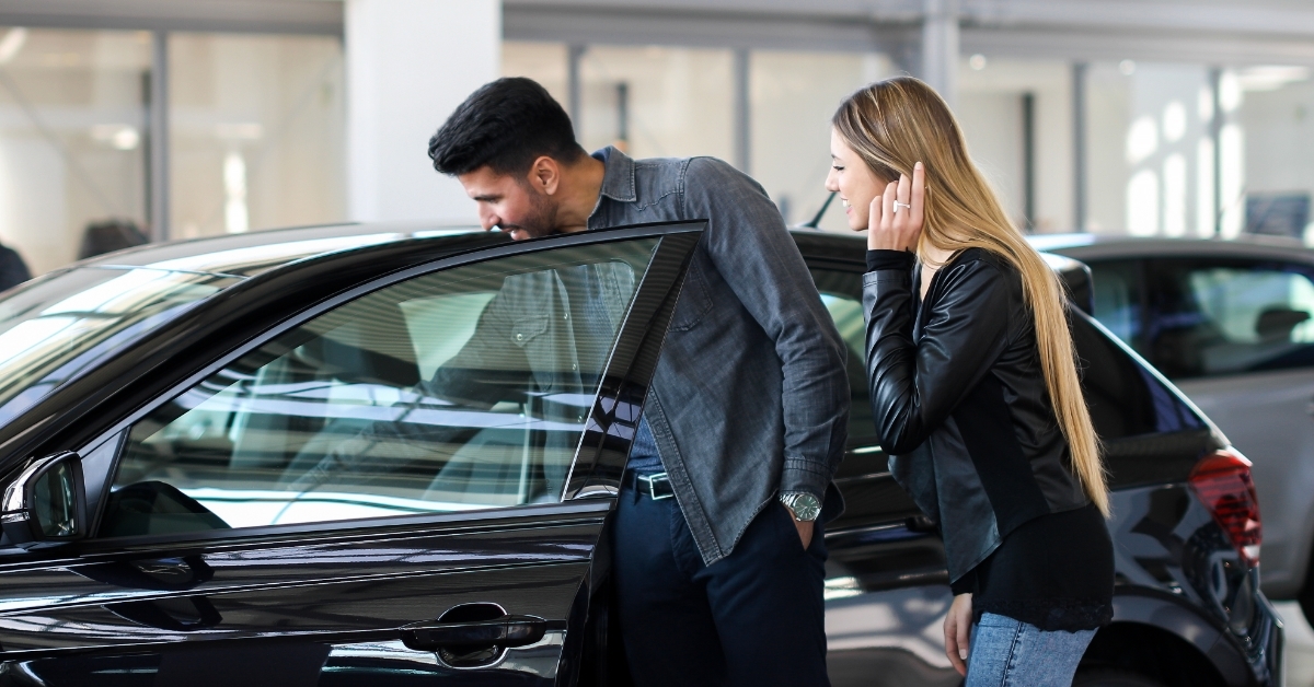 couple choosing car at dealership shop