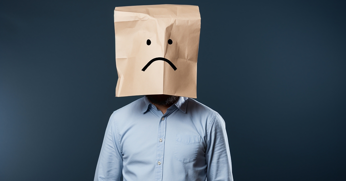 man wearing sad paper bag