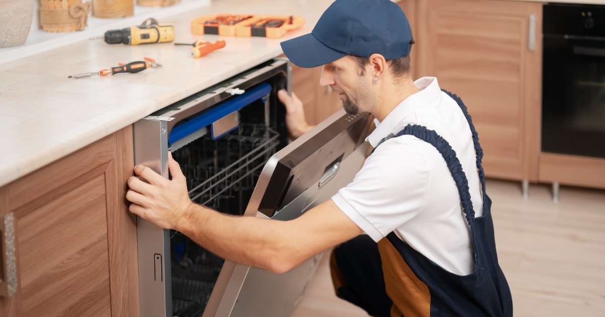 service worker installing dishwasher in kitchen