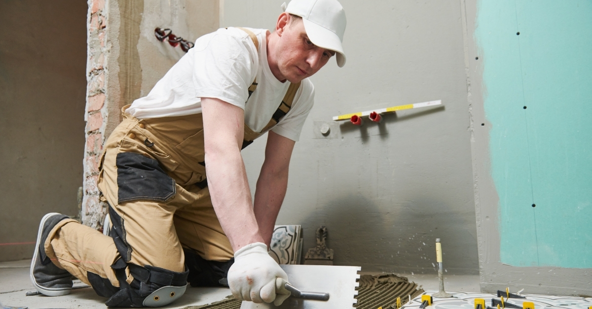 Tiler installing tile on bathroom floor