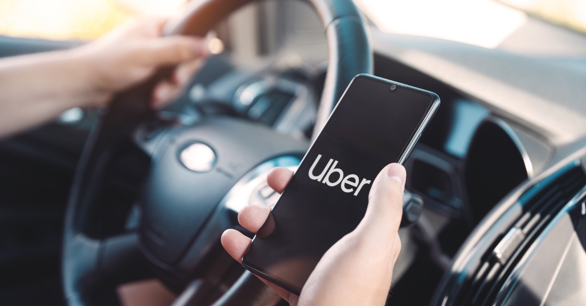 Uber driver holding smartphone in car
