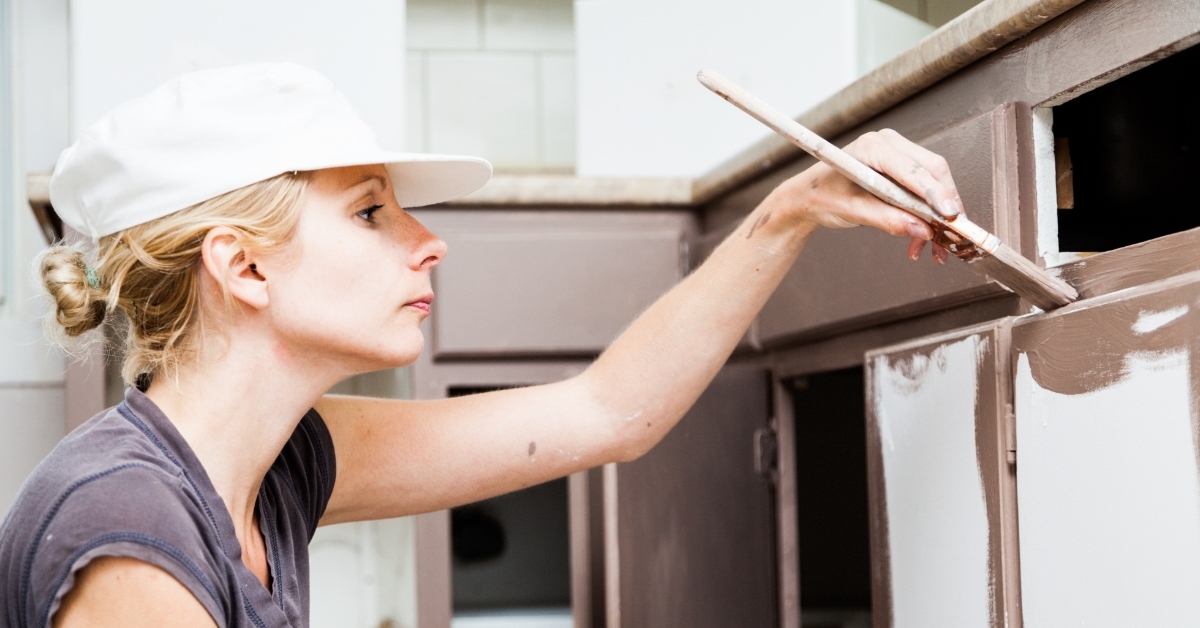 focused Woman Painting Kitchen Cabinets