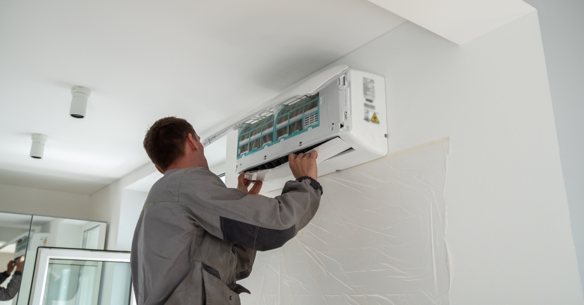 worker installing air conditioner in apartment