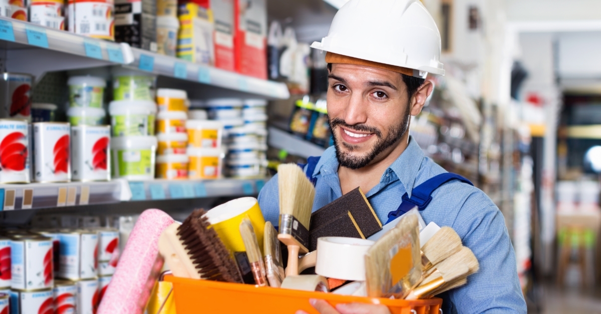 workman holding basket of painting tools