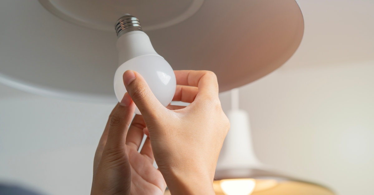 woman hands changing light bulb