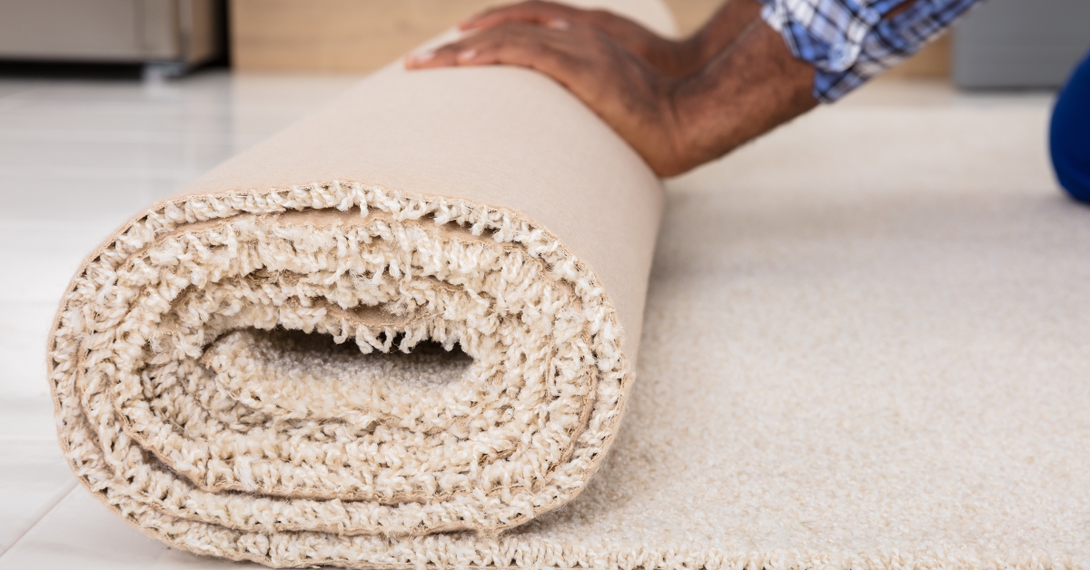 workers hands rolling carpet