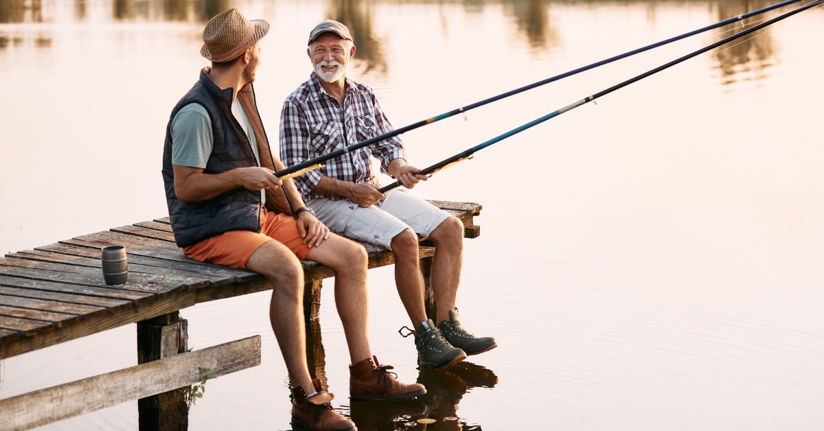 senior man fishing with son