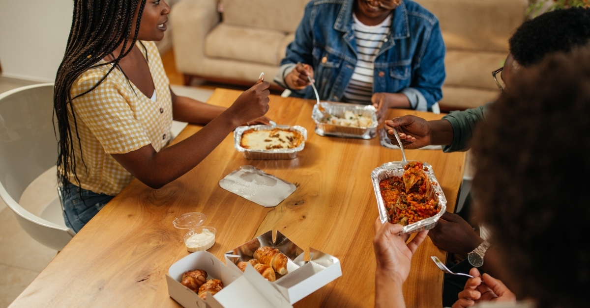 african american friends eating food together