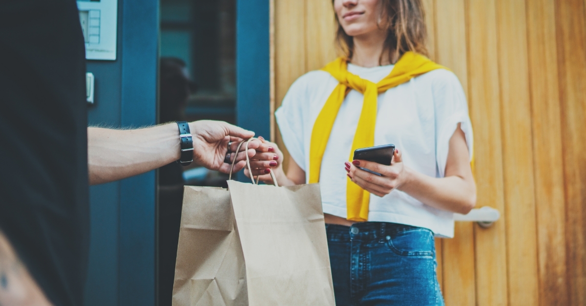 delivery man giving food to woman