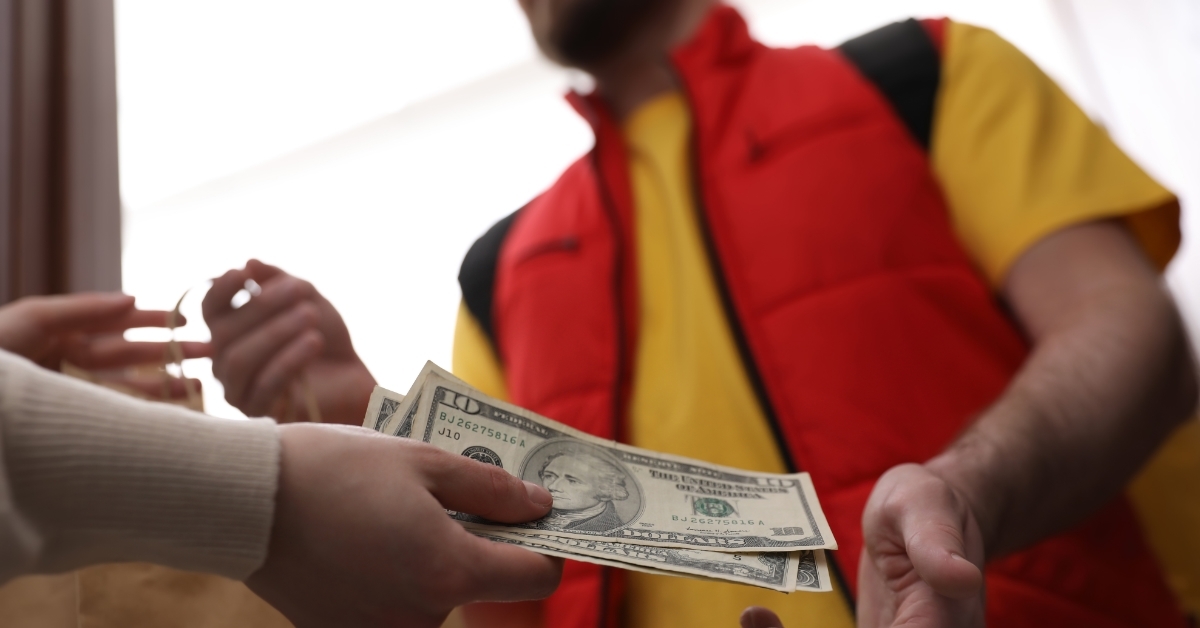 Delivery man receiving tips from woman