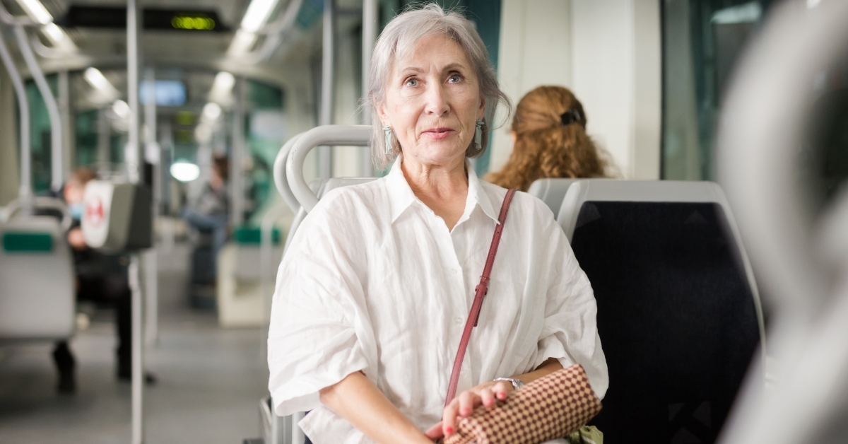 senior woman sitting inside tram