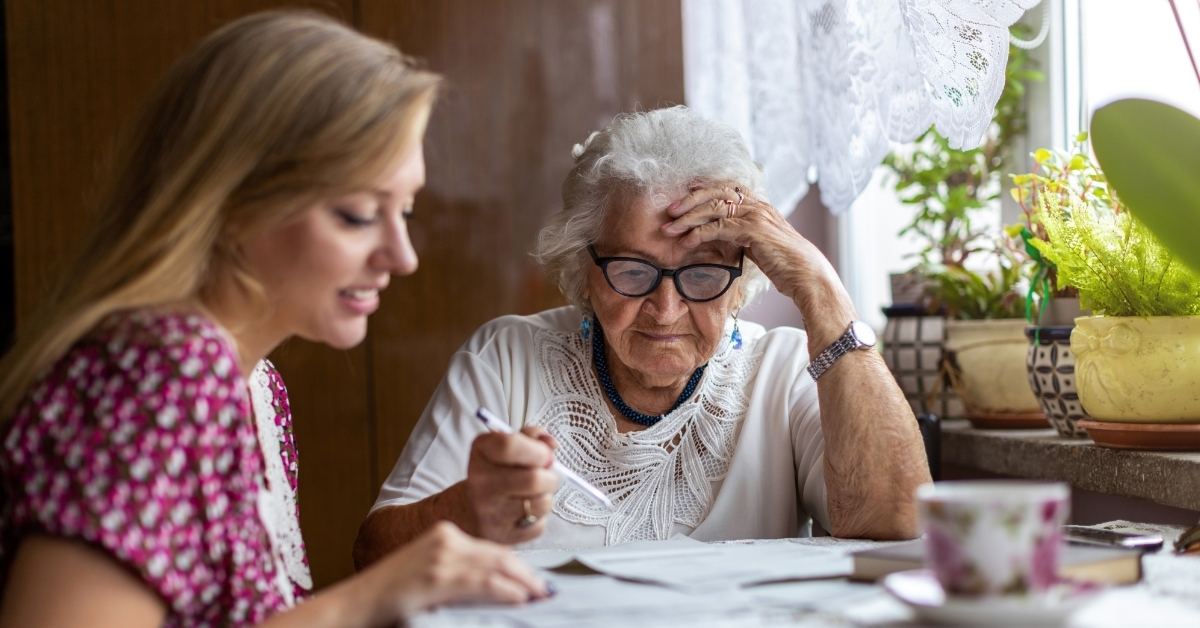 woman helping grandmother with paperwork