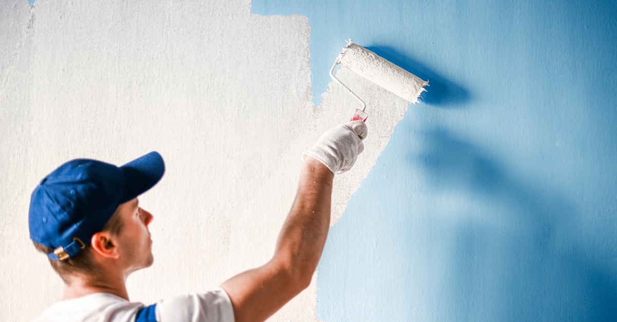 Painter painting wall with roller