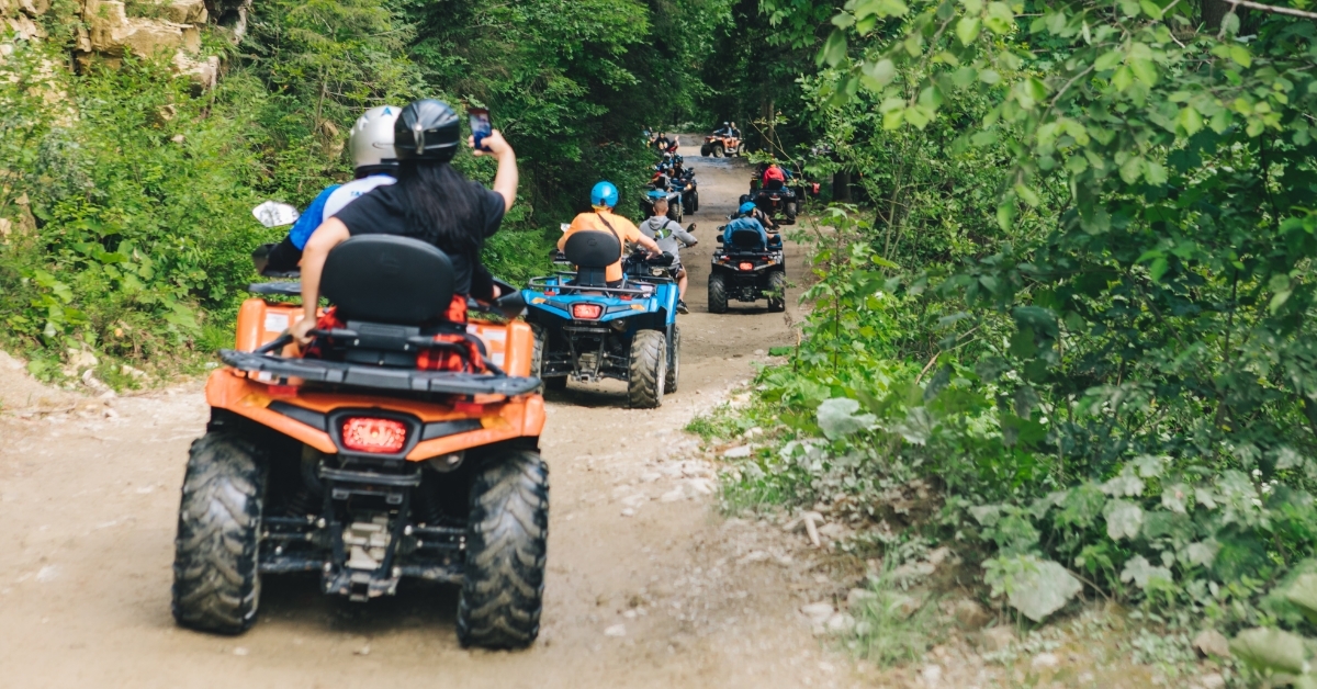 people having atv ride in woods