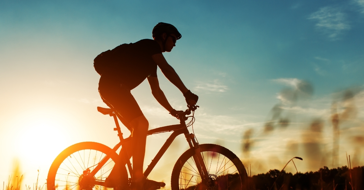 man riding bicycle at sunset
