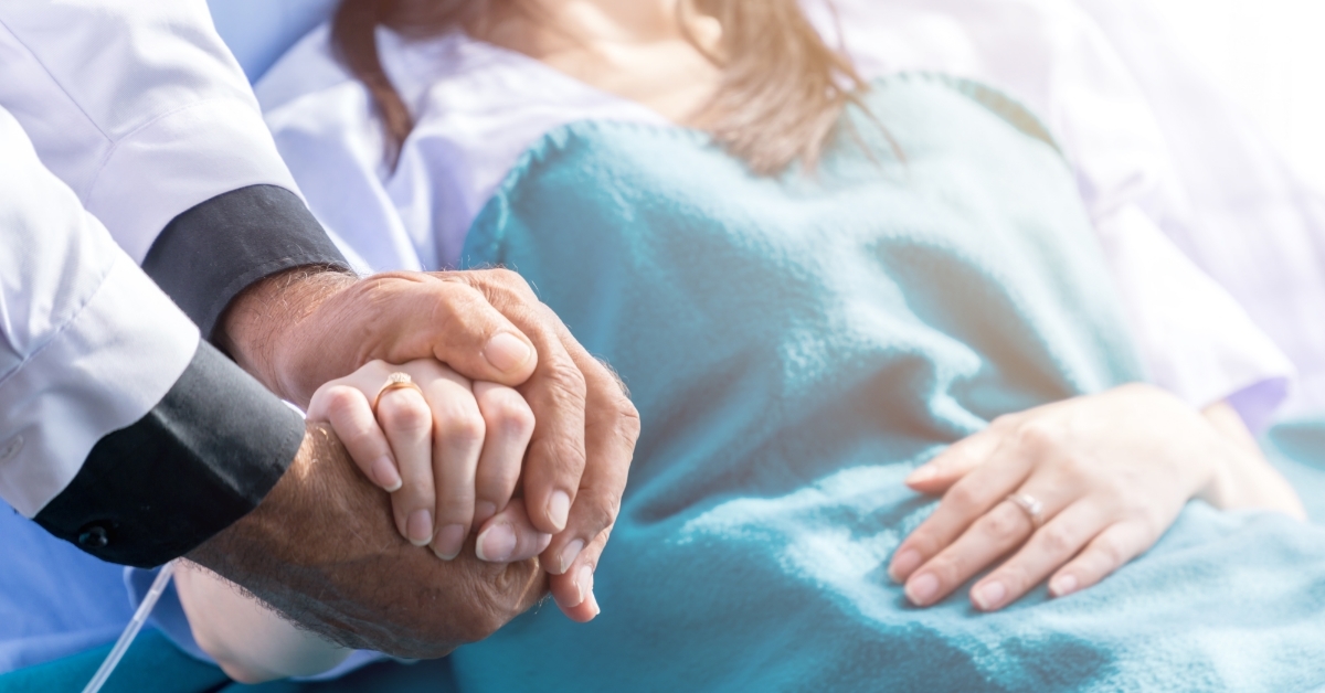 male doctor holding female patient hand