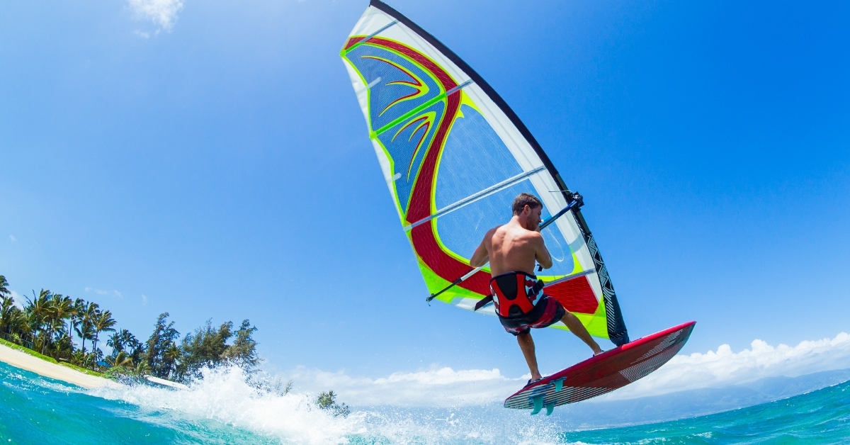 man windsurfing in blue water