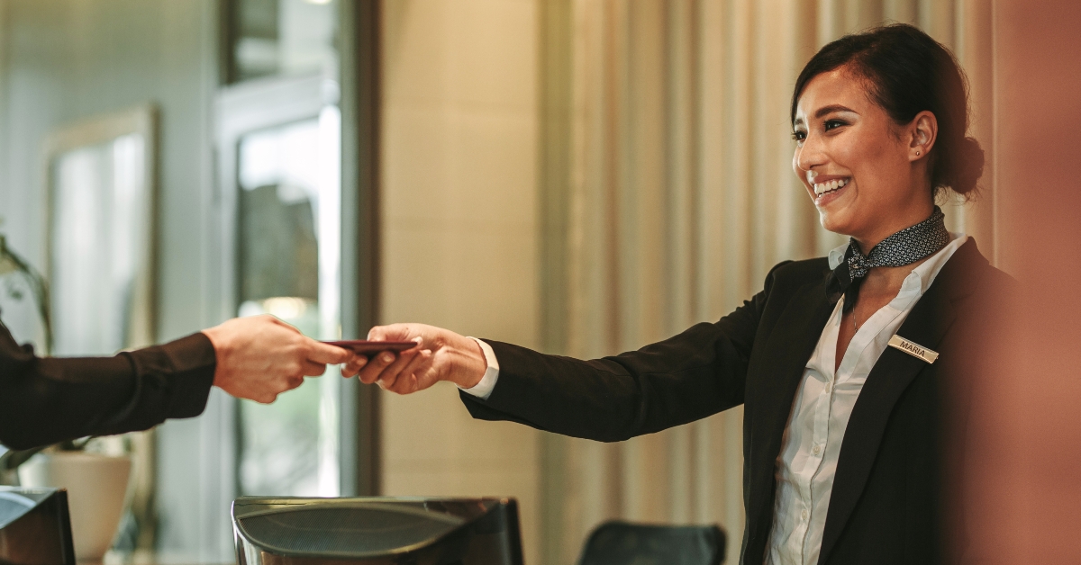 smiling receptionist attending hotel guest