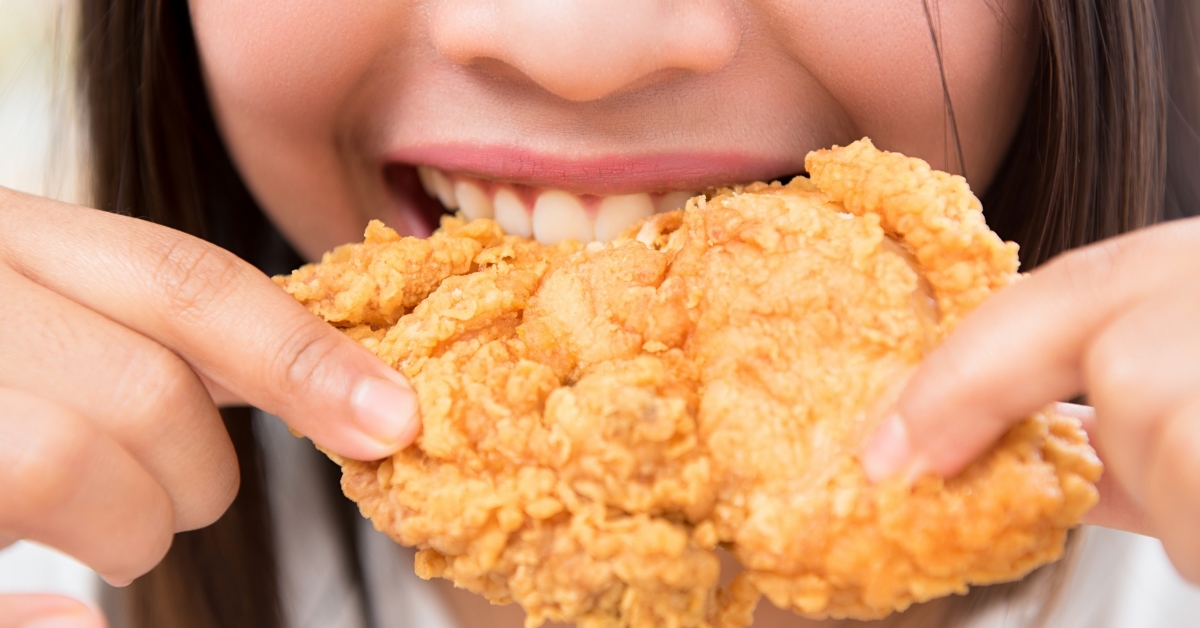 woman eating deep fried chicken