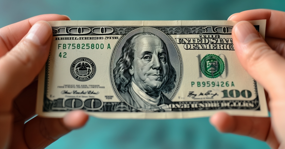 holding a crisp green banknote