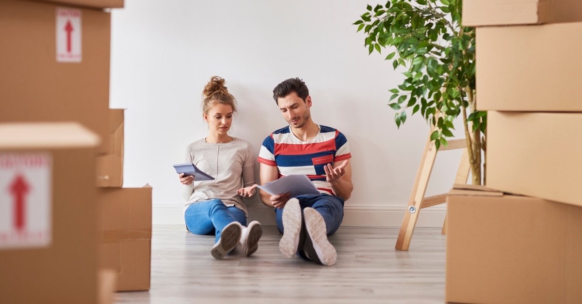 couple examining expenses besides moving boxes