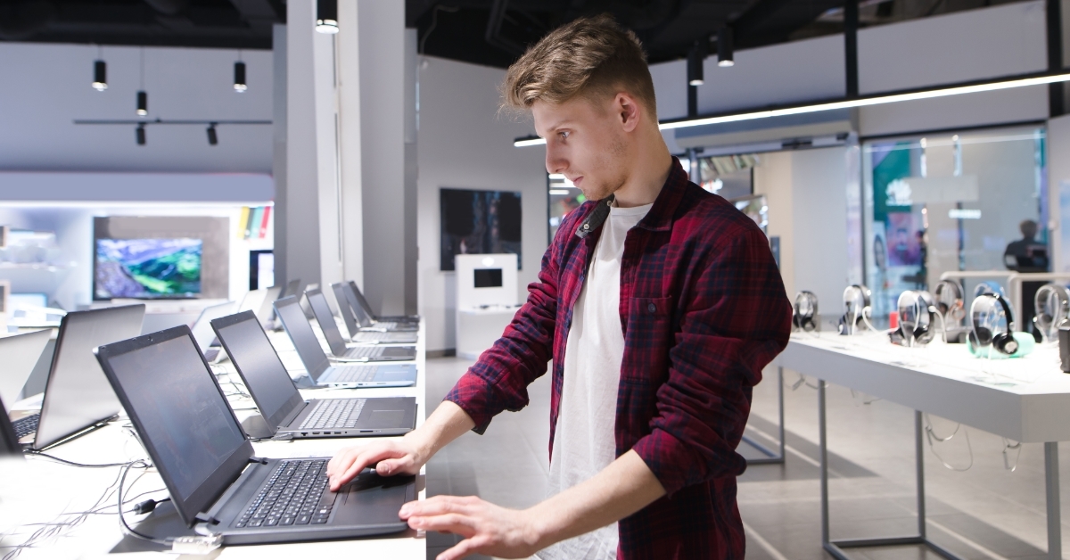 man checking laptop in electric store