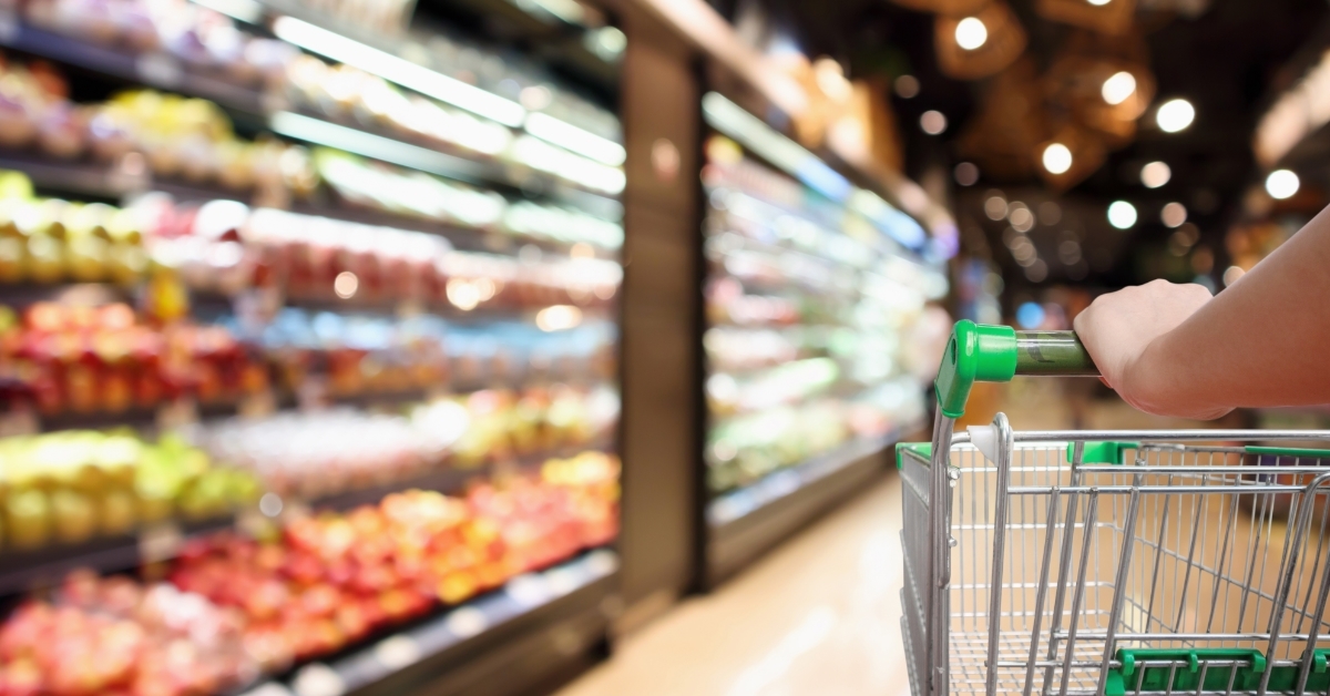 woman with shopping cart at supermarket