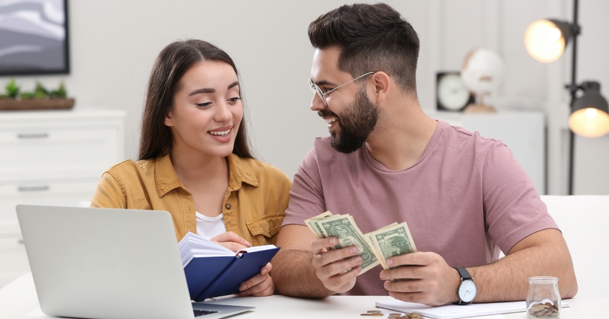 couple counting money while reviewing budget
