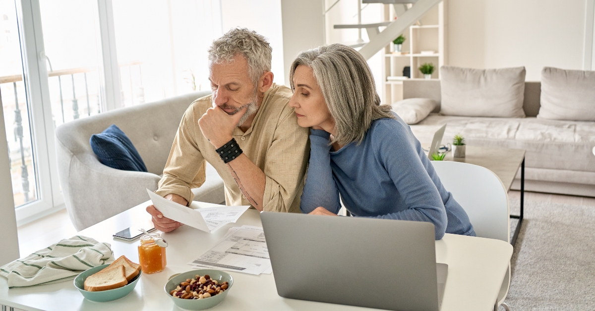 worried senior couple checking documents