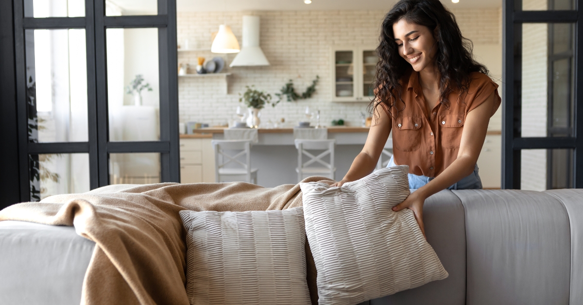 young woman putting soft pillows