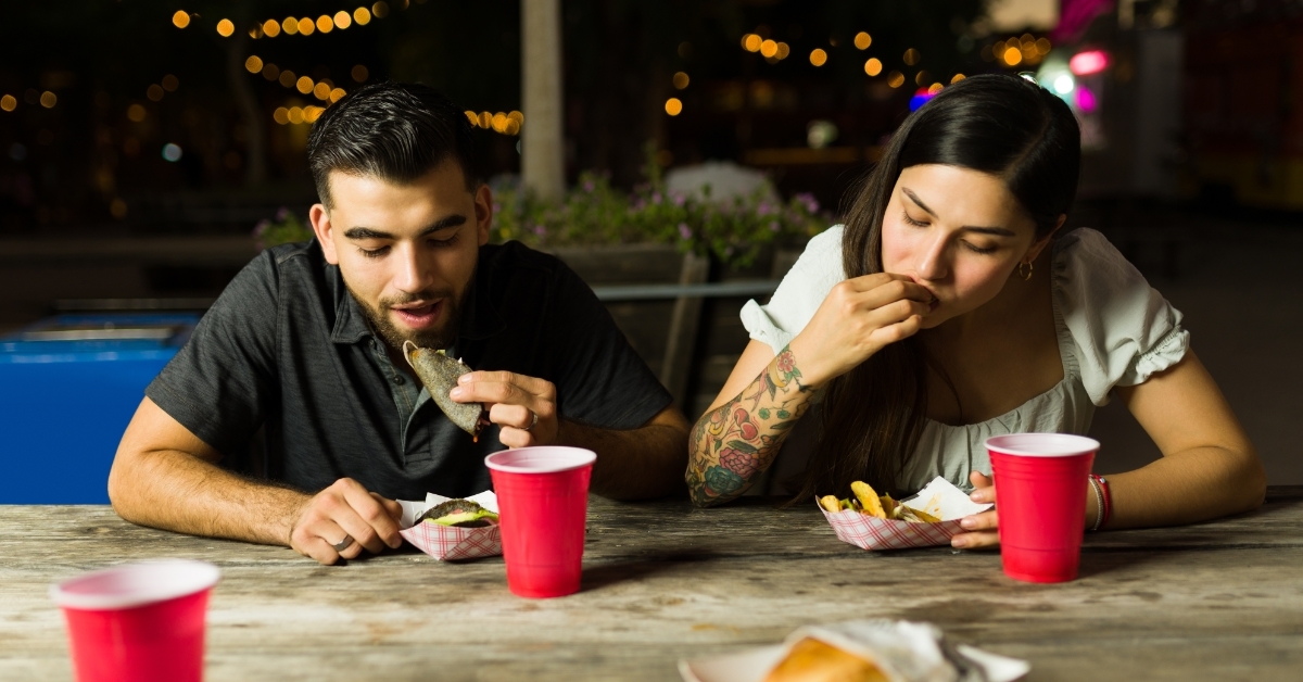 couple eating delicious tacos at night