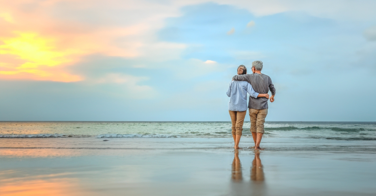 senior couple walking on the beach