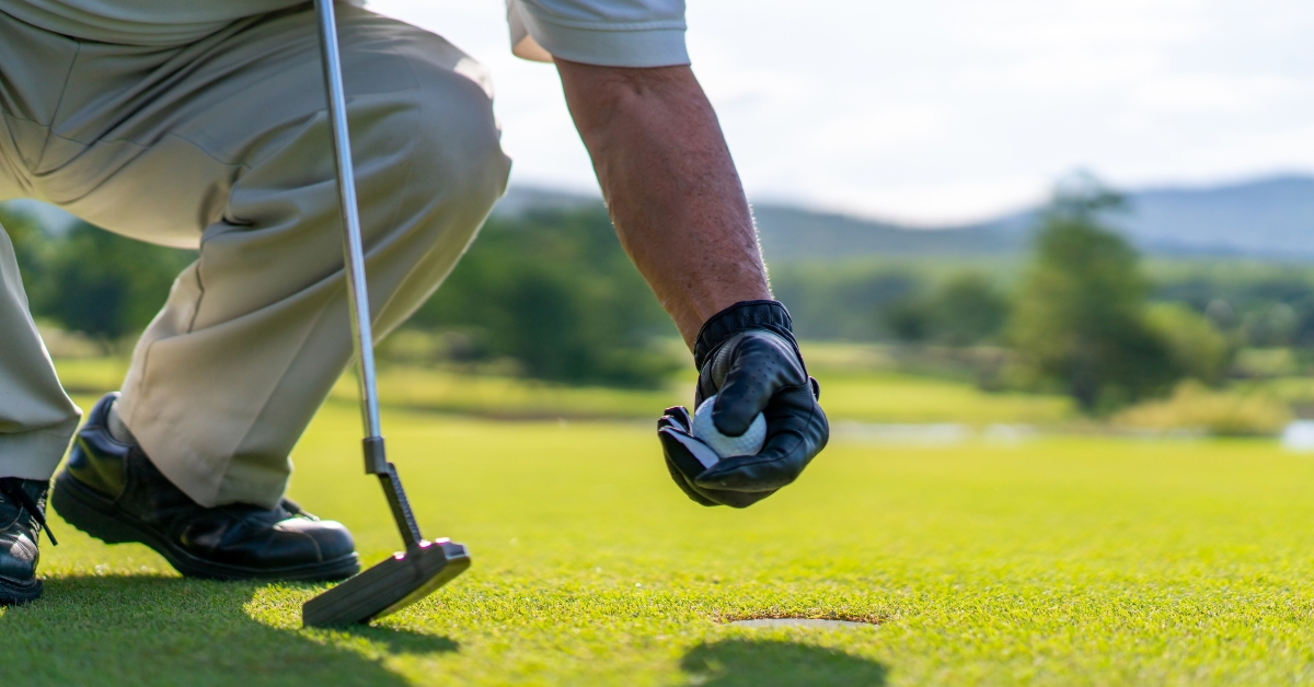 golfer picking golf ball