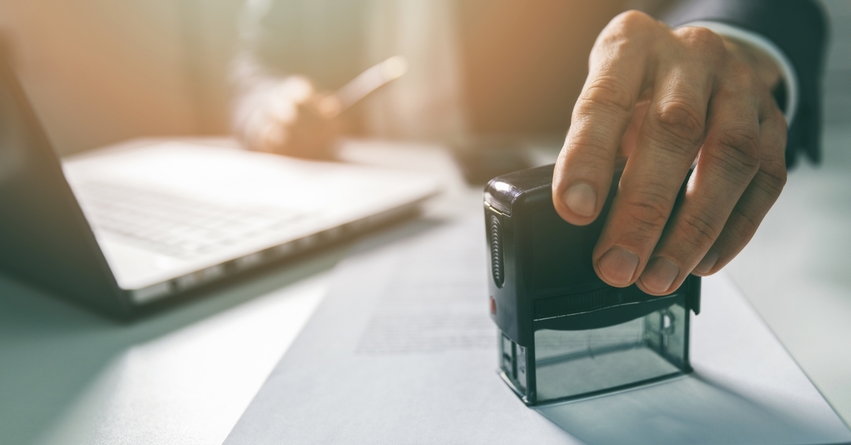 businessman stamping contract in office