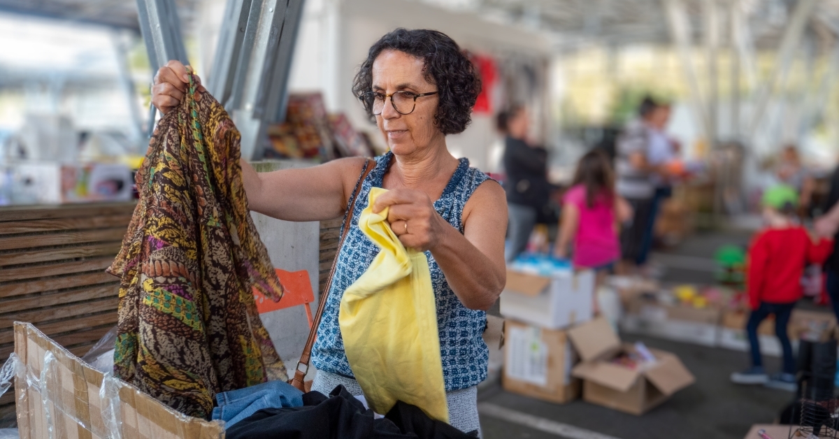 woman choosing clothes at garage sale