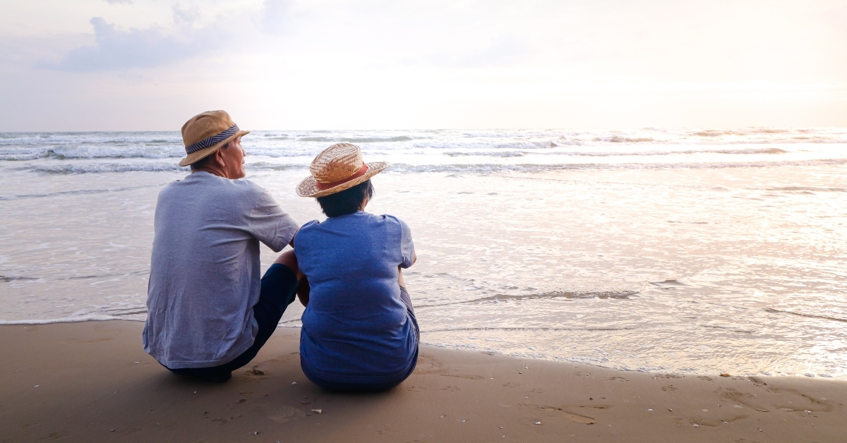asian couple sitting on the beach