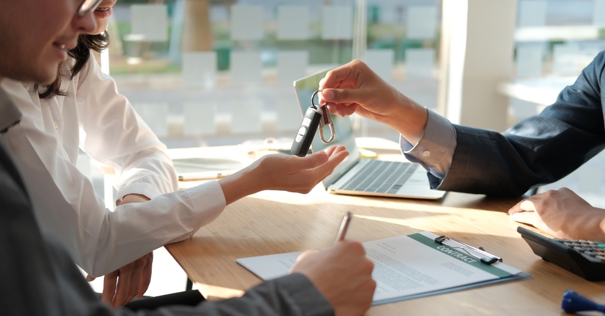 car dealer giving keys to owner