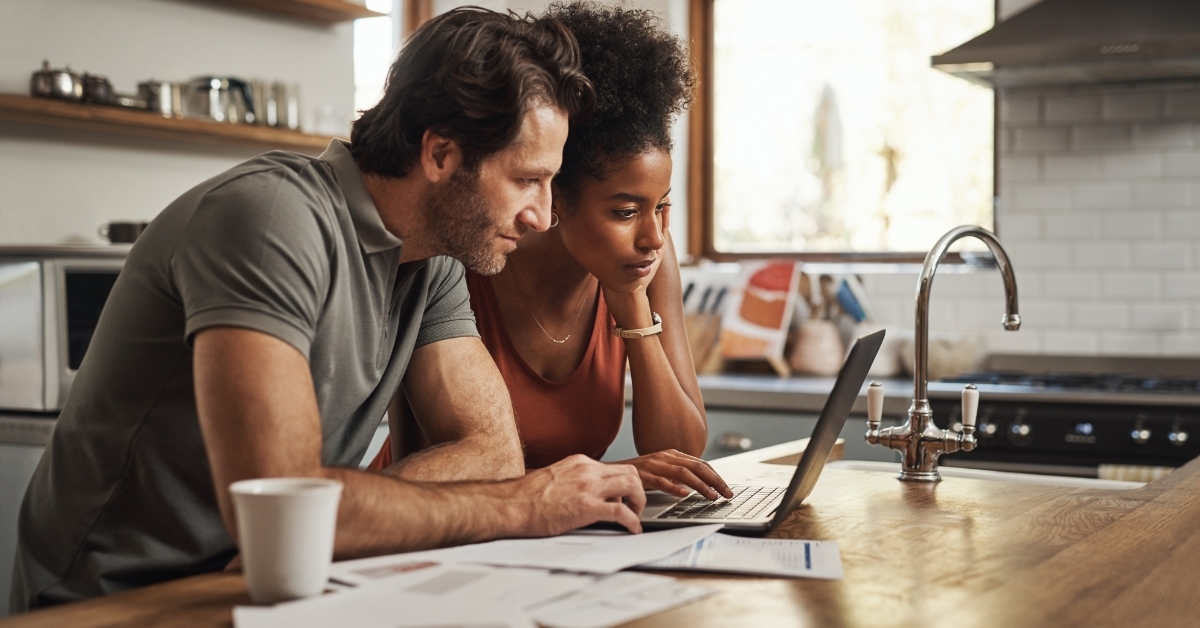 interracial couple reviewing bills in kitchen